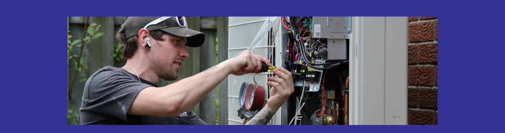 A Cross technician carefully works on the internal components of a heat pump. This image introduces a blog about air source heat pumps.