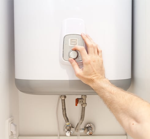 Hand adjusts knob on boiler.