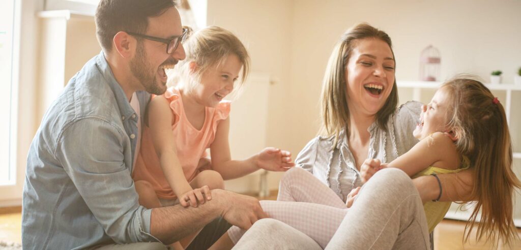 Parents playing with two small children.