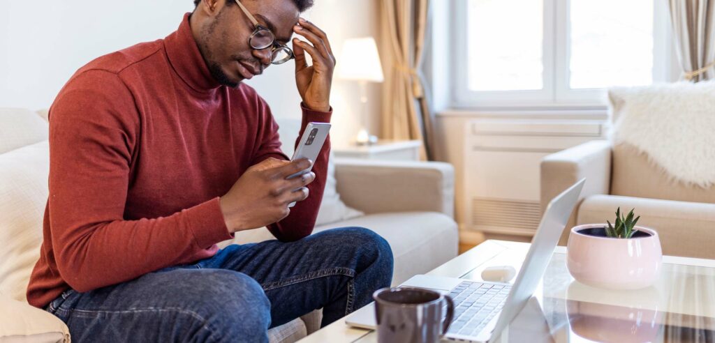 Man holding phone appearing to be frustrated.