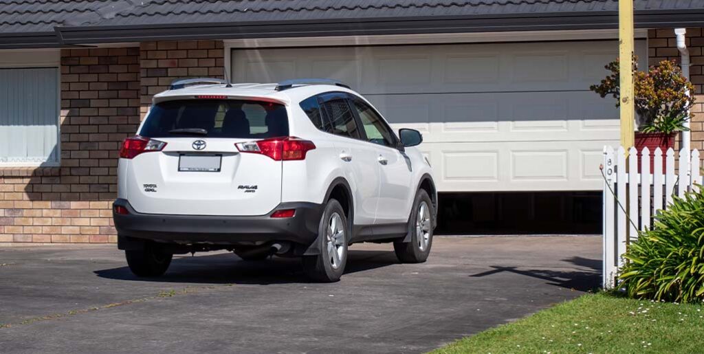 Toyota RAV4 about to enter garage of home.