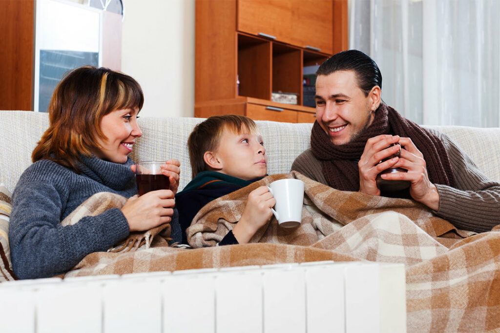 Family enjoying warmth of furnace in Ontario home