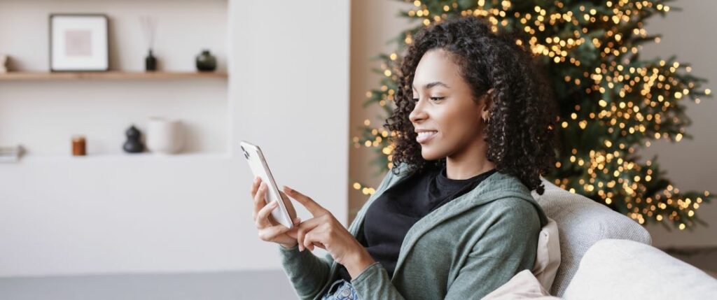 Woman checking her smart thermostat from her phone.