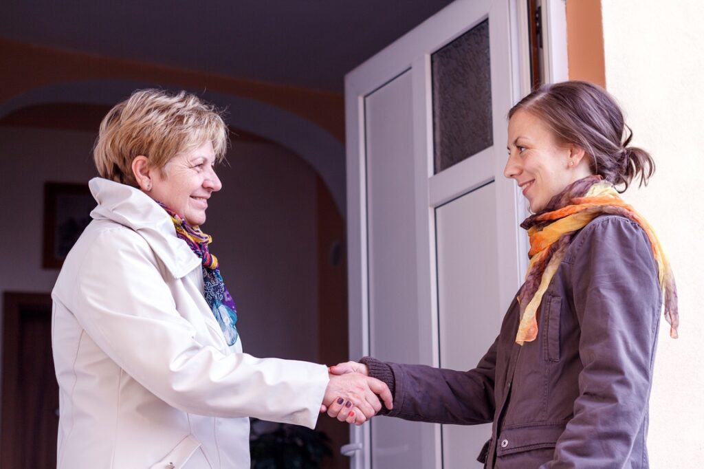 Senior women greeting young girl in the doorway